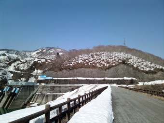 ダムを渡る道<br>
雪のなし<br>
奥に鷲鞍岳